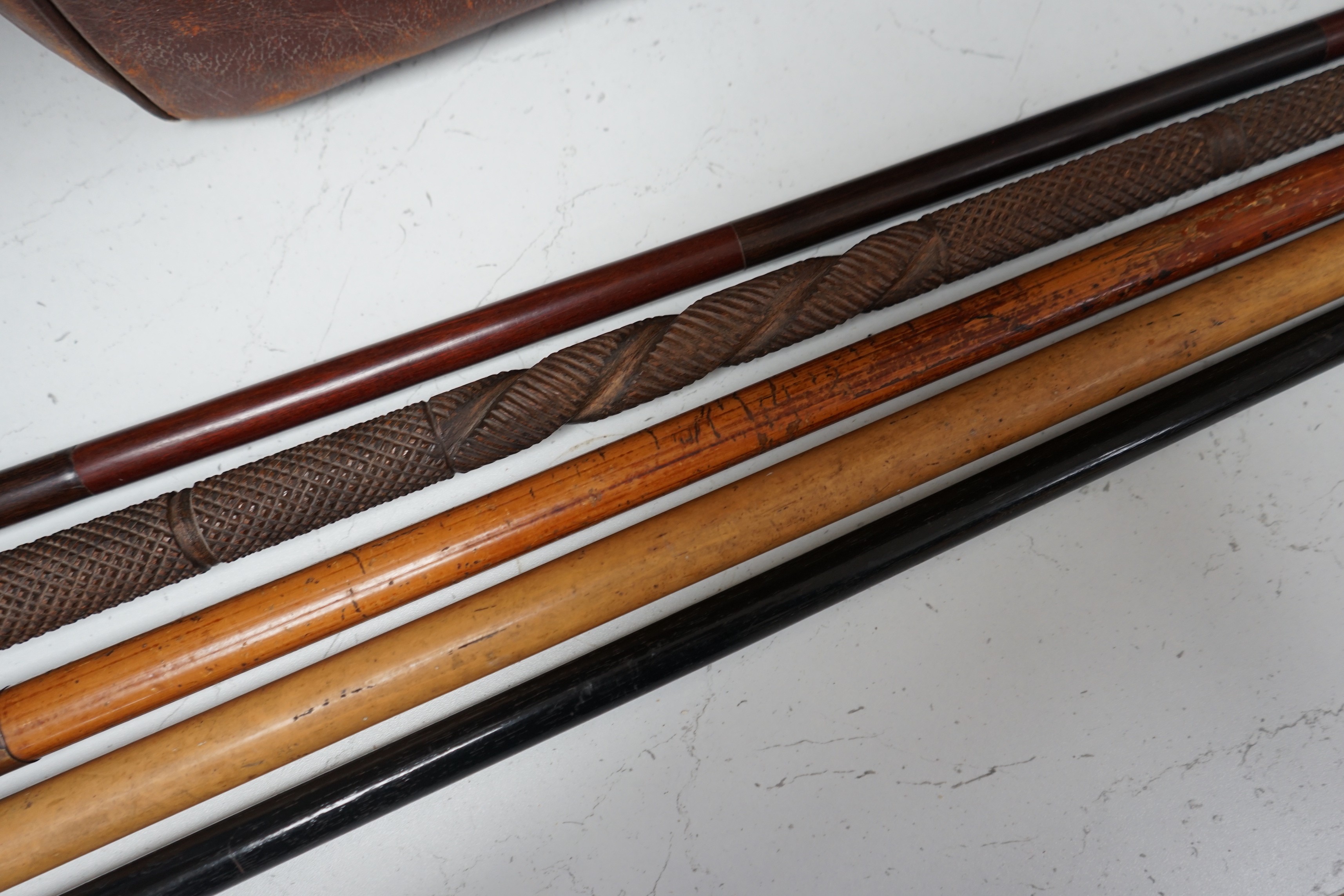 A collection of five walking sticks including one silver mounted and a Gladstone bag